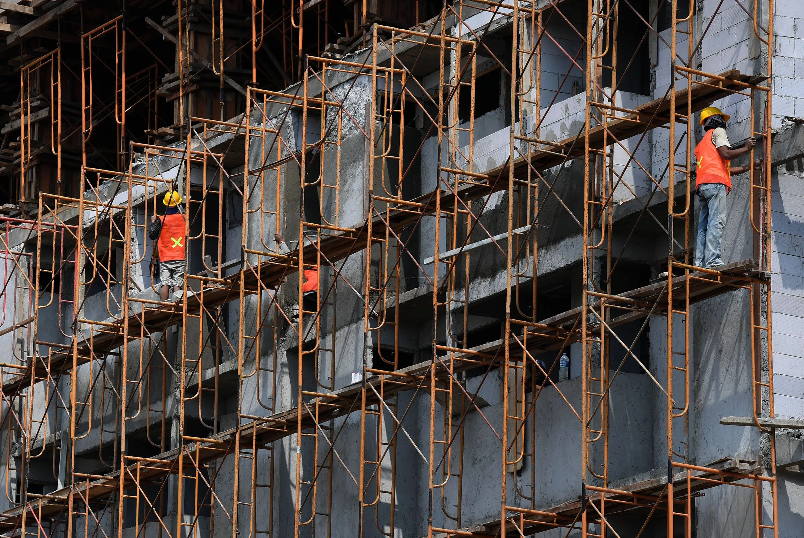 Pekerja konstruksi menggunakan scaffolding pada bangunan bertingkat